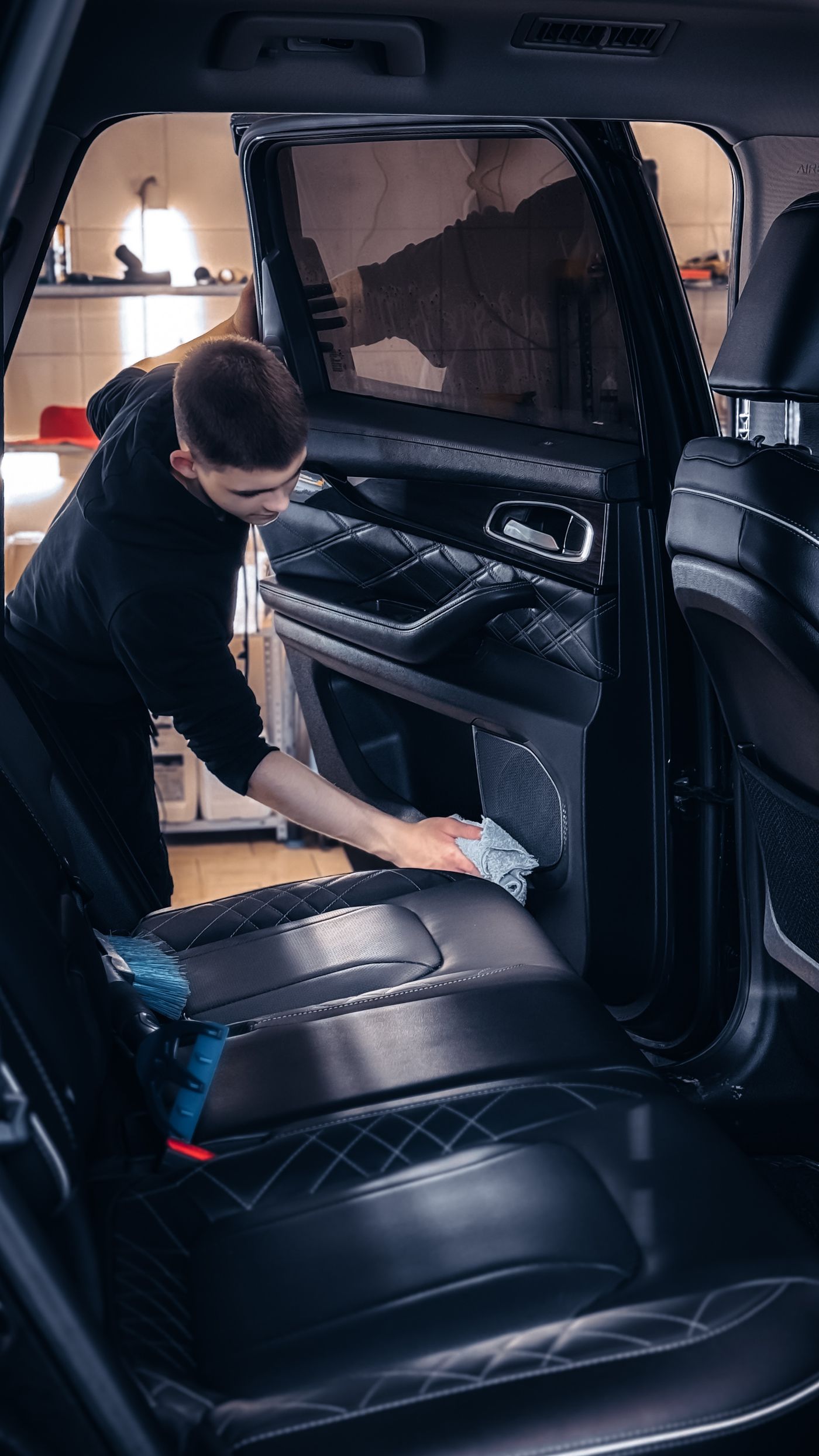 Technician wiping down a car door panel