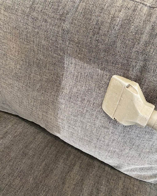 Fabric sofa being steam cleaned by Prestige